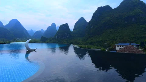 Guilin Yangshuo China, luxury infinity pool with crescent moon decor, karst moun Stock-Footage 332558024