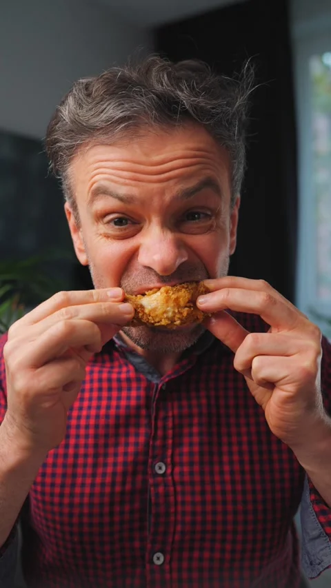 Guilty pleasure. Man eating fried chicken leg, enjoying fast food. Stock Footage 342835039