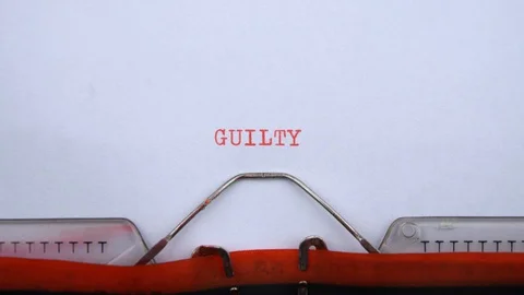 Guilty - word printed on an old typewriter in red letters, close up. Video stock 128400395