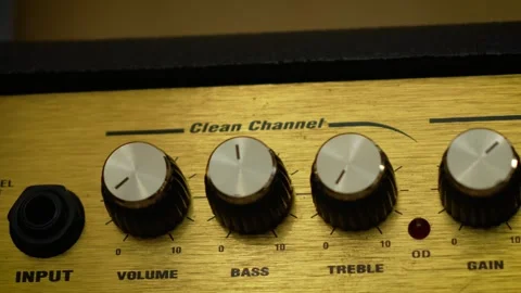 Guitar amplifier control panel with volume, bass, and treble knobs. Macro Stock Footage 337640968