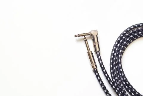 Guitar cable with right-angle and straight jack plugs isolated on white. Stock Photos