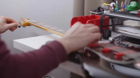 Guitar changes strings on the electric guitar, repair of the musical instruments Stock Footage 281007607