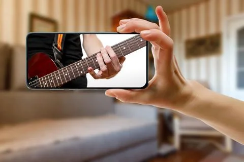 Guitar lessons tutorial with smart phone. Indoor screen shot of musical cours Stock Photos