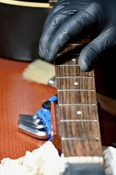 Guitar Luthier Installing New String on Acoustic Guitar Headstock and Fretboard Stock Photos