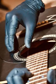 Guitar Luthier Plucking and Testing Single New String on Acoustic Guitar Body Stock Photos