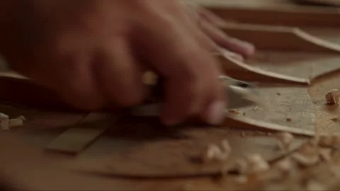Guitar luthier using small planer to fine-tune bracing of acoustic guitar. Stock Footage 251803487