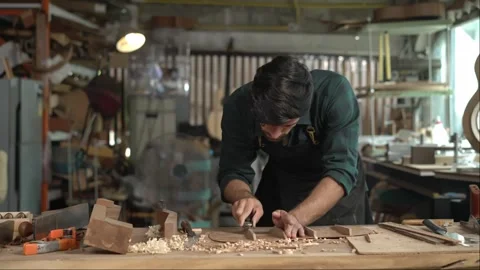 Guitar luthier using small planer to fine-tune bracing of acoustic guitar Stock Footage 251803632