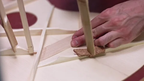 Guitar maker adds structural strenght to a home made guitar Stock Footage 113887742