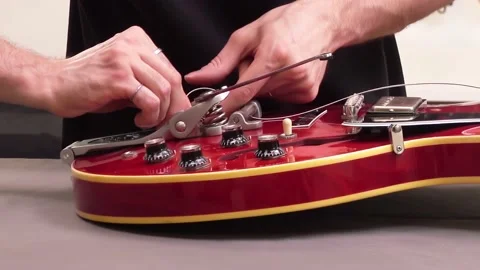 Guitar maker assembling or repairing an electric guitar. Stock Footage 141881030