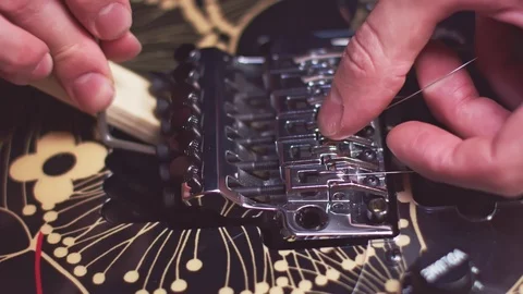 Guitar maker fix strings on the bridge Stock Footage 118014163