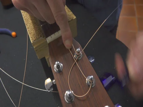 Guitar Maker Installing New Strings on Classical Guitar Видео 72611324