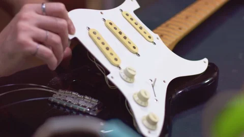 Guitar maker repairs a broken guitar and screw the pickguard Stock Footage 118017378