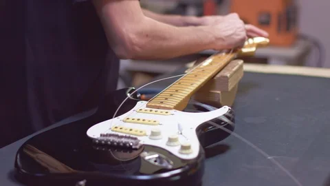 Guitar maker repairs strings of a guitar Stock Footage 118017744