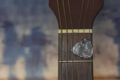 Guitar pick held between strings on neck. Guitar plectrum. Musical instruments. 스톡 사진