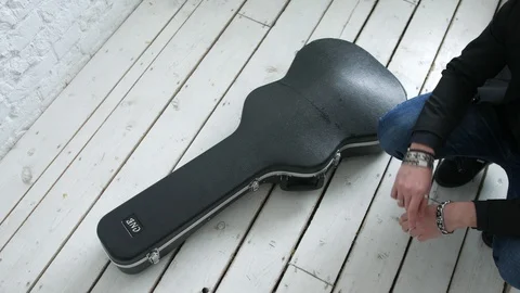 Guitar player opens guitar case 库存影片 104044942