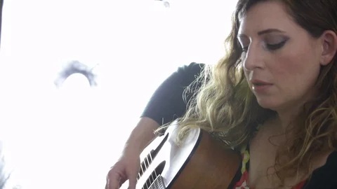 Guitar player passionately sings while she plays Stock Footage 98754756