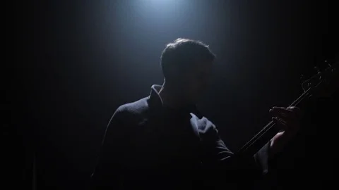 Guitar Player plays with a single light in the background Stock-Footage 82406305