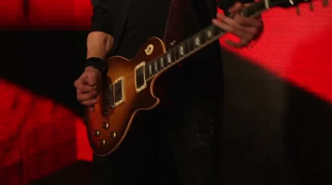 Guitar player on a red background Stock Footage 45997484