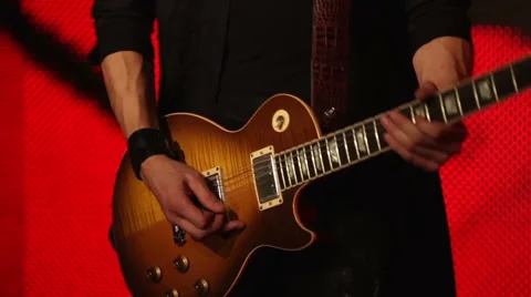 Guitar player on a red background Stock Footage 45997507