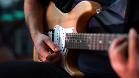 Guitar player sitting and playing slowly e-guitar Video stock 108105201