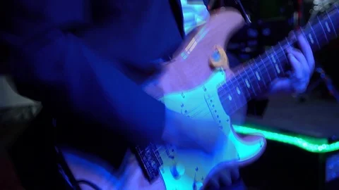 The guitar player is very active on stage with his rock band.  close-up Stock Footage 91684187
