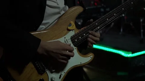 The guitar player is very active on stage with his rock band.  close-up,  fla Video stock 91684266