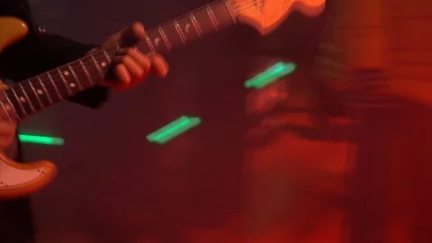 The guitar player is very active on stage with his rock band. Medium shot Video stock 91684364