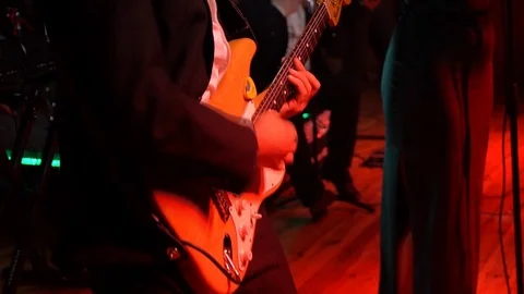 The guitar player is very active on stage with his rock band. Medium shot Video stock 91684637