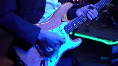 The guitar player is very active on stage with his rock band.  close-up Video stock 91685638