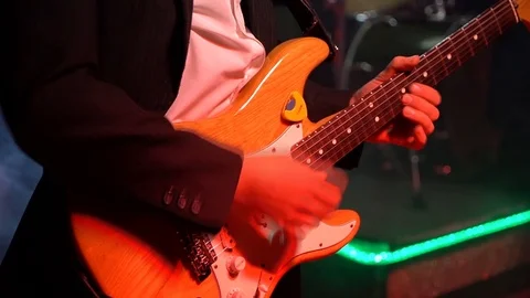 The guitar player is very active on stage with his rock band.  close-up Video stock 91685734