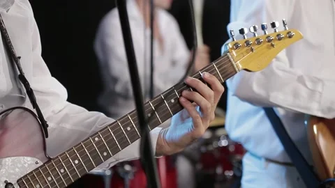 The guitar player is very active on stage with his rock band. close-up Stock Footage 143992362