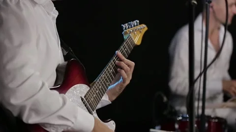 The guitar player is very active on stage with his rock band. close-up Stock Footage 143992435