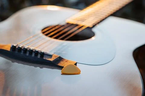Guitar with a plectrum against setting evening sun Stock Photos