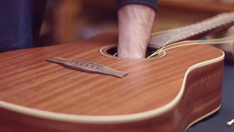 Guitar repair, man changes the strings Видео 102057678