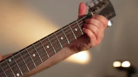 Guitar strings, soft light glimmers in the background, creating a tranquil Video stock 293095322