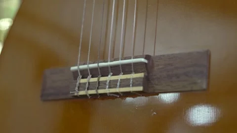 Guitar strings vibrate during a music lesson in a studio on a sunny afternoon Stock Footage 334012733