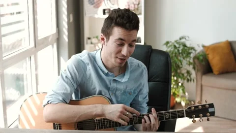 Guitar teacher looking at camera and explaining how to play guitar. Stock Footage 202276096
