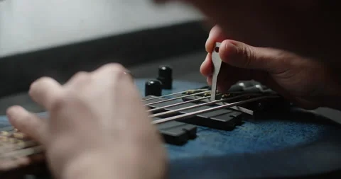 Guitar tech adjusts the string radius of the bass guitar, repair of the musical Stock Footage 166392425