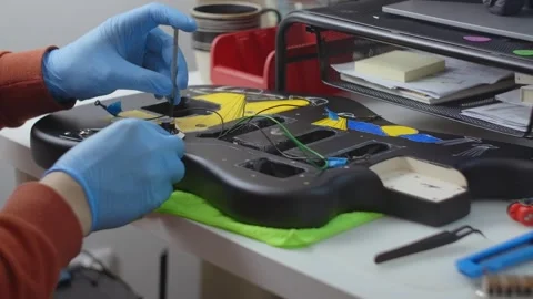 Guitar tech assembles the guitar, repair of the musical instruments at the Stock Footage 279658672
