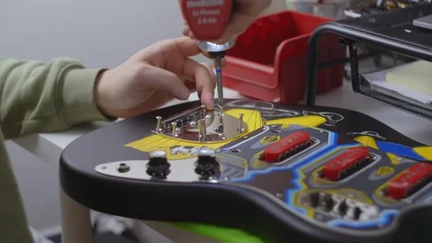 Guitar tech assembles the guitar, repair of the musical instruments at the Stock Footage 282713078