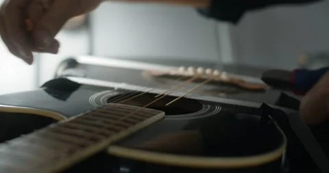 Guitar tech cuts the strings on the acoustic guitar by nippers in slow motion Video stock 164308973