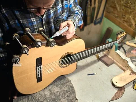 In the guitar workshop, Guitars Luthiers sets up a stand under the arm. Stock Photos