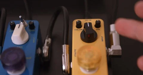 Guitarist Adjusting Knobs And Switches On Guitar Effect Pedals. Dolly Shot. Video stock 114642241