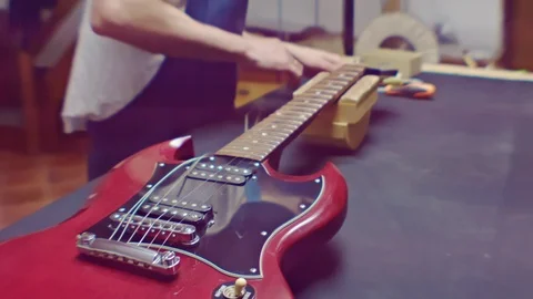 Guitarist changes guitar strings Stock Footage 105257365