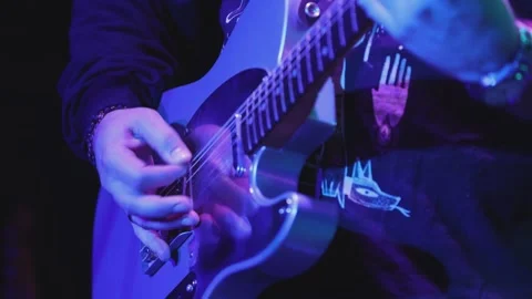 Guitarist during variable spotlights strumming electric guitar during live rock Video stock 308232496