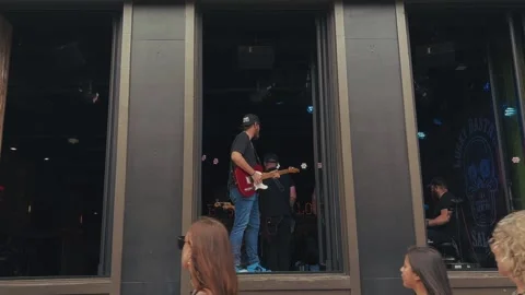 Guitarist performing by open saloon window Nashville Stock Footage 322878713