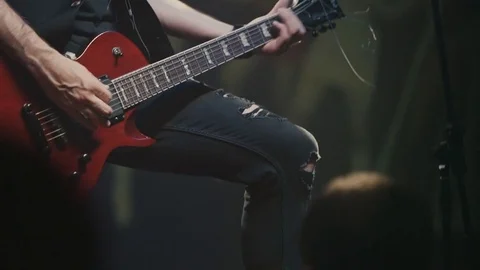 Guitarist plays on a red electric guitar at a rock concert Stock Footage
