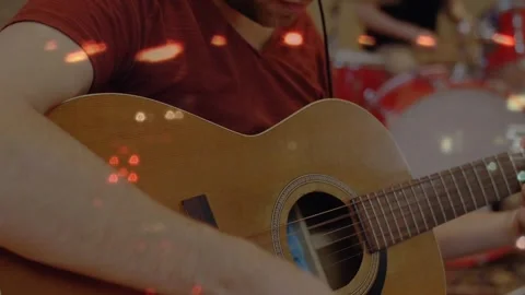 Guitarist touching strings, picking, camera widening revealing red kit, bokeh Stock Footage 330237687