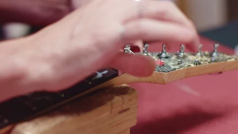 Guitarist wrap string with peg Stock Footage 117987356