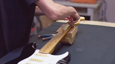 Guitarist wrap strings with a peg Stock Footage 118017851